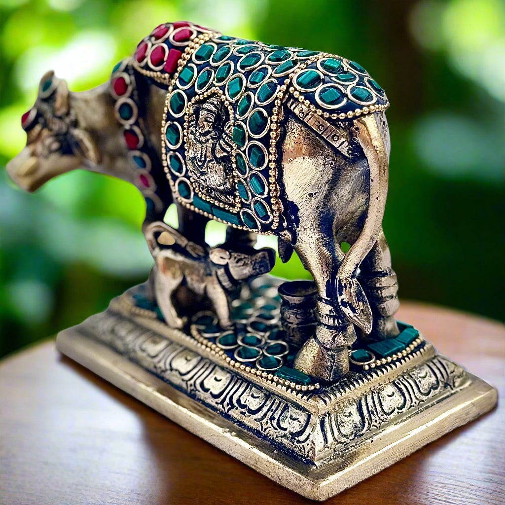 Decorative elephant figurine with intricate designs and colored stones on a white background